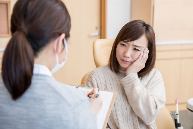 歯科スタッフと問診を受ける女性患者
