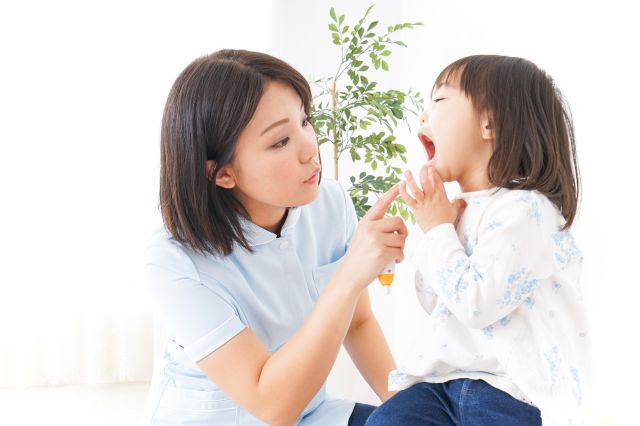 女の子の口内を見る女性歯科スタッフ