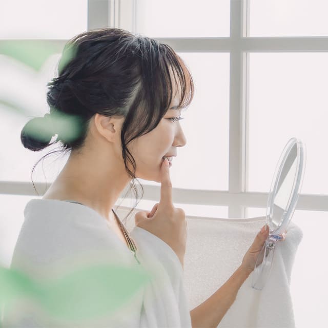 鏡を見ている女性